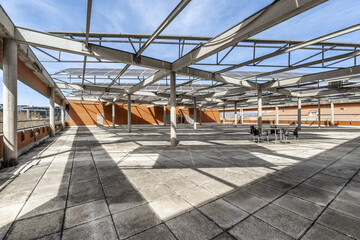 Penthouse of an office building with a large terrace with a metal structure supporting solar panels
