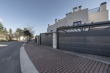 Urbanization with gray folding portals of the garage door of a single-family home
