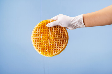 Put on nitrile gloves and sprinkle syrup on the round waffle.
