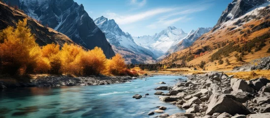 Foto op Canvas A river meanders through a mountain valley, embraced by towering trees and rugged rocks, under the vast sky dotted with fluffy clouds © AkuAku