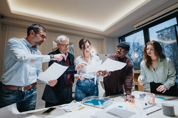 A multiethnic group of business professionals engaging in a collaborative discussion during a team meeting, showcasing teamwork and strategy. - Powered by Adobe