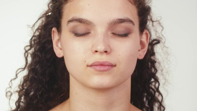 Eye shadow makeup to the upper eyelid, close-up. Makeup artist applies a bright eye shadow with a make-up brush.Tutorial master class of professional makeup, smoky eyes 