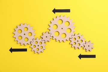 Business process organization and optimization. Scheme with wooden figures and arrows on yellow...