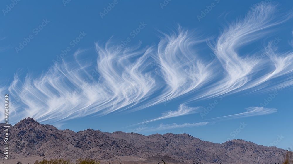 Poster a group of white clouds in a blue sky over a desert landscape with a mountain range in the distance 
