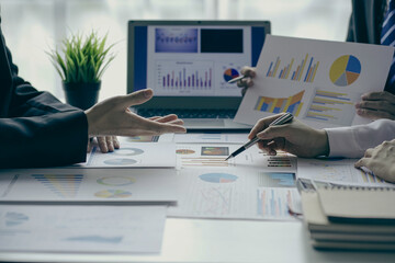 A team of analysts works on a financial data analysis dashboard on paper to use as market indicators for planning, strategic brainstorming, financial investments and marketing new business projects.