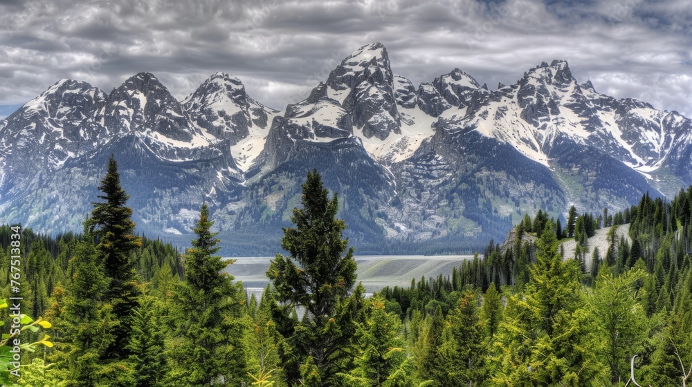 Poster a view of a mountain range with trees in the foreground and a body of water in the foreground.