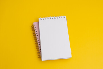 Notebook with a wish list to-do list on yellow background, flat lay style. Planning concept.