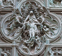 MILAN, ITALY - SEPTEMBER 16, 2024: The detail from main bronze gate of the Cathedral -   Deposition (Pieta) by Ludovico Pogliaghi (1906). - 767519266