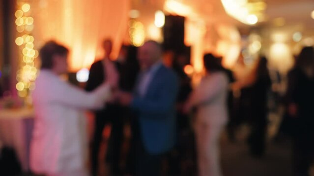 Joyful movement: man and woman dancing at lively party in blurred image