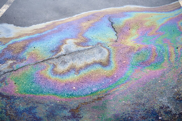 Spills of fuel or oil on the asphalt road as texture or background