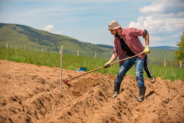 Male farmer working on an agricultural fields in spring.
