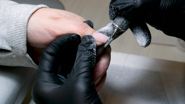 Beautician using a nail polish giving customer service a manicure at salon