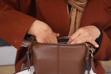 women looking for something in her purse