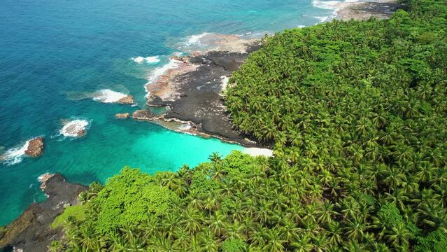 Aerial tilt shot revealing the Bateria beach on Rolas island in Sao Tome, Africa