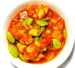 Petai or Pete with Shrimp, cooked with mashed red chili. This food is called Balado Udang Pete, isolated on dinner preparation. Selective focus.
