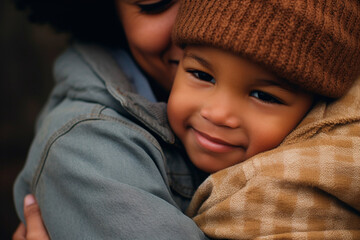 African-American mother lovingly hugging her African-American son. Side view mother hugging kid