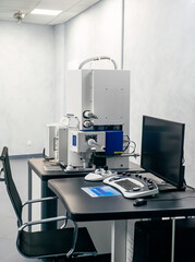 Work space of a scientist with Electron microscope, table and computer