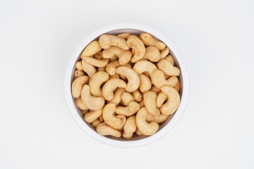 Top view of delicious cashew nuts in a white bowl Isolated Background