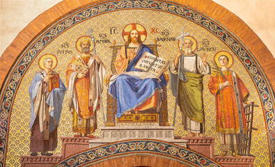 MILAN, ITALY - MARCH 6, 2024: The mosaic of Jesus the Pantokrator and Teacher among the saints in the church Basilica di San Babila by  workroom Murano-Venezia (1929).