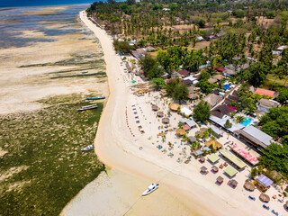 Aerial view of colorful sun loungers and parasols on a small tropical beach (Gili Islands, Lombok,...