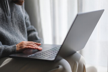 Closeup image of a woman working and touching on laptop computer touchpad at home - obrazy, fototapety, plakaty