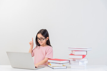 a student on the table and laptop among a large number of books