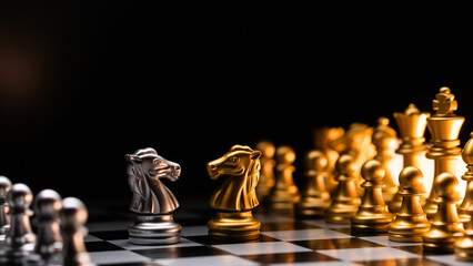 Duel of knights. Silver against gold on chessboard.