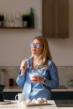 Woman tasting yogurt in sunlit kitchen