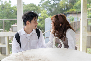 A scene where a young Taiwanese male and female couple in their 20s sit and talk happily in the Maokong, a tourist destination in Taiwan. 20代の若い台湾人の男女カップルが台湾の観光地である猫空で座って仲良く話す光景