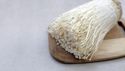 Fresh Enoki mushrooms on wooden cutting board