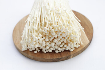 Fresh Enoki mushrooms on wooden cutting board