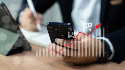 Sale growth concept. Businessman touching graph of increase in sales volume with shopping cart on...