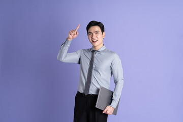 Obraz na płótnie Canvas Portrait of Asian male businessman posing on purple background