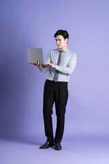 Portrait of Asian male businessman standing and posing on purple background