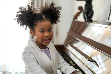 African young child creativity and learning playing piano, talented pianist engrossed in music, music schools and project aiming to portray joy of learning instrument, beginning of a musical journey
