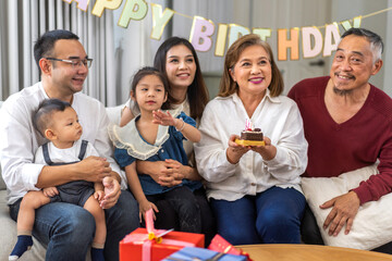 Portrait of happy love asian big family father and mother with asian baby and little girl happy birthday, party, celebration, cake, surprise, grandfather with grandmother smiling together.Family party