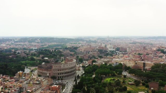 Aerial: Colosseum Surrounded By Streets And Buildings In City Against Sky - Rome, Italy