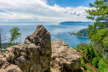 Beautiful summer panoramic landscape with stone at hill and view to lake. Chersky stone in Listvyanka village at Baikal lake coast. Amazing siberian nature. Chersky stone at Baikal, Siberia, Russia