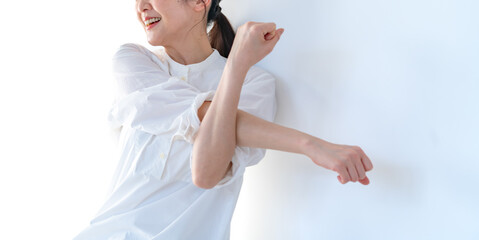 伸びをするワンピースを着たミドルの日本人女性