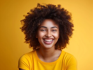 A woman with curly hair is smiling and wearing a yellow jacket