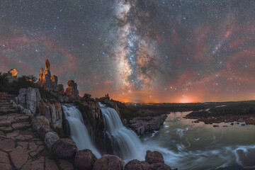 A beautiful night sky with a large body of water and a waterfall - Powered by Adobe