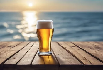 Badezimmer Foto Rückwand A glass of beer on a wooden jetty with the sea in the golden hour  © Ina Meer Sommer