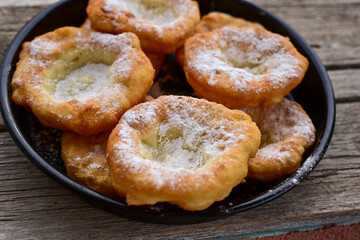 Traditional Bulgarian home made deep fried  patties  covered with sugar  оn rustic backgroud.Mekitsa or Mekica,  on wooden  rustic  background. Made of kneaded dough that is deep fried 