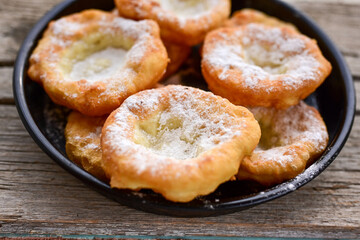 Traditional Bulgarian home made deep fried  patties  covered with sugar  оn rustic backgroud.Mekitsa or Mekica,  on wooden  rustic  background. Made of kneaded dough that is deep fried 