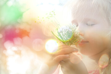 Little girl picking summer flowers. Happy child enjoying nature outdoors. Sunlit  little girl...