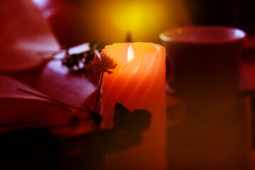 Candlelight in the dark, flowers,. Cozy evening at home. vintage toned. Burning candle. Atmospheric...