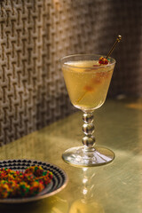 candy cocktail: cocktail pick full of candy clusters in bubbly drink on golden brass table