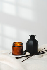Elegant Aroma Diffuser With Reed Sticks And Scented Candle On White Tablecloth