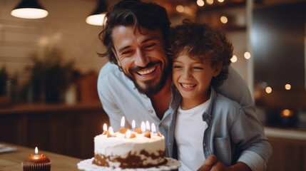 A man and a boy are standing in front of a birthday cake with candles