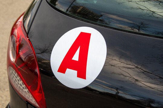 Disque autocollant "A" (pour "Apprenti") placé à l'arrière d'une voiture signalant en France que le véhicule est conduit par un jeune conducteur soumis aux règles du permis de conduire probatoire